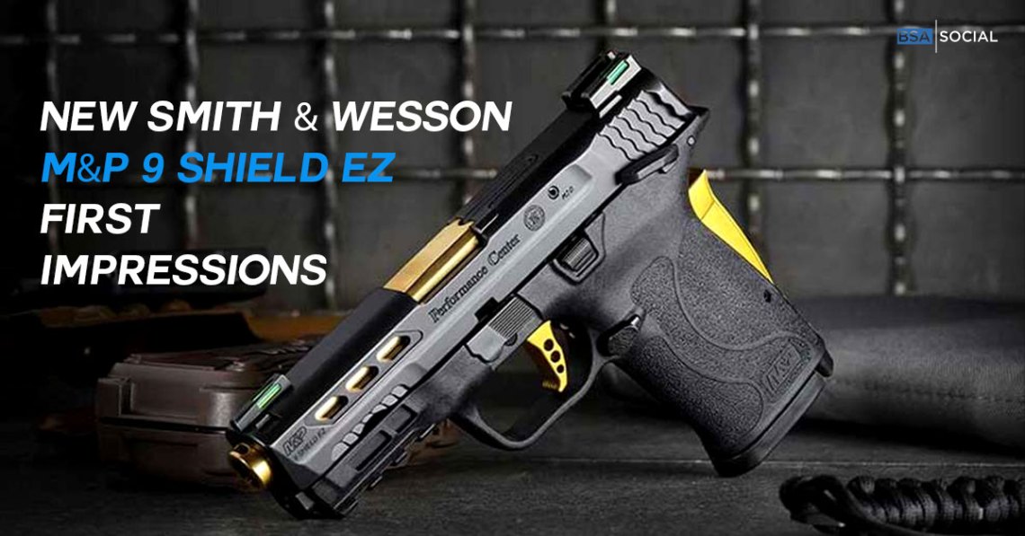 A Smith & Wesson M&P 9 Shield EZ pistol with black and gold accents, placed on a dark surface with a tactical background. The text overlay reads "NEW SMITH & WESSON M&P 9 SHIELD EZ FIRST IMPRESSIONS" in white and blue.